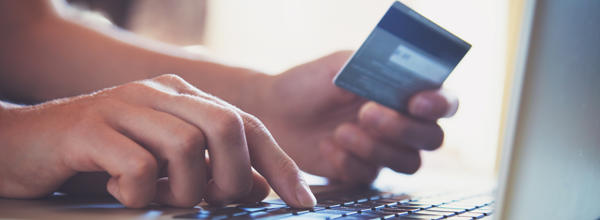 Someone on a laptop with their debit card paying rent