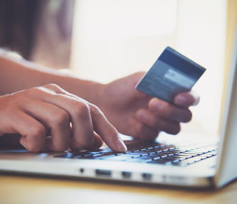 Someone on a laptop with their debit card paying rent
