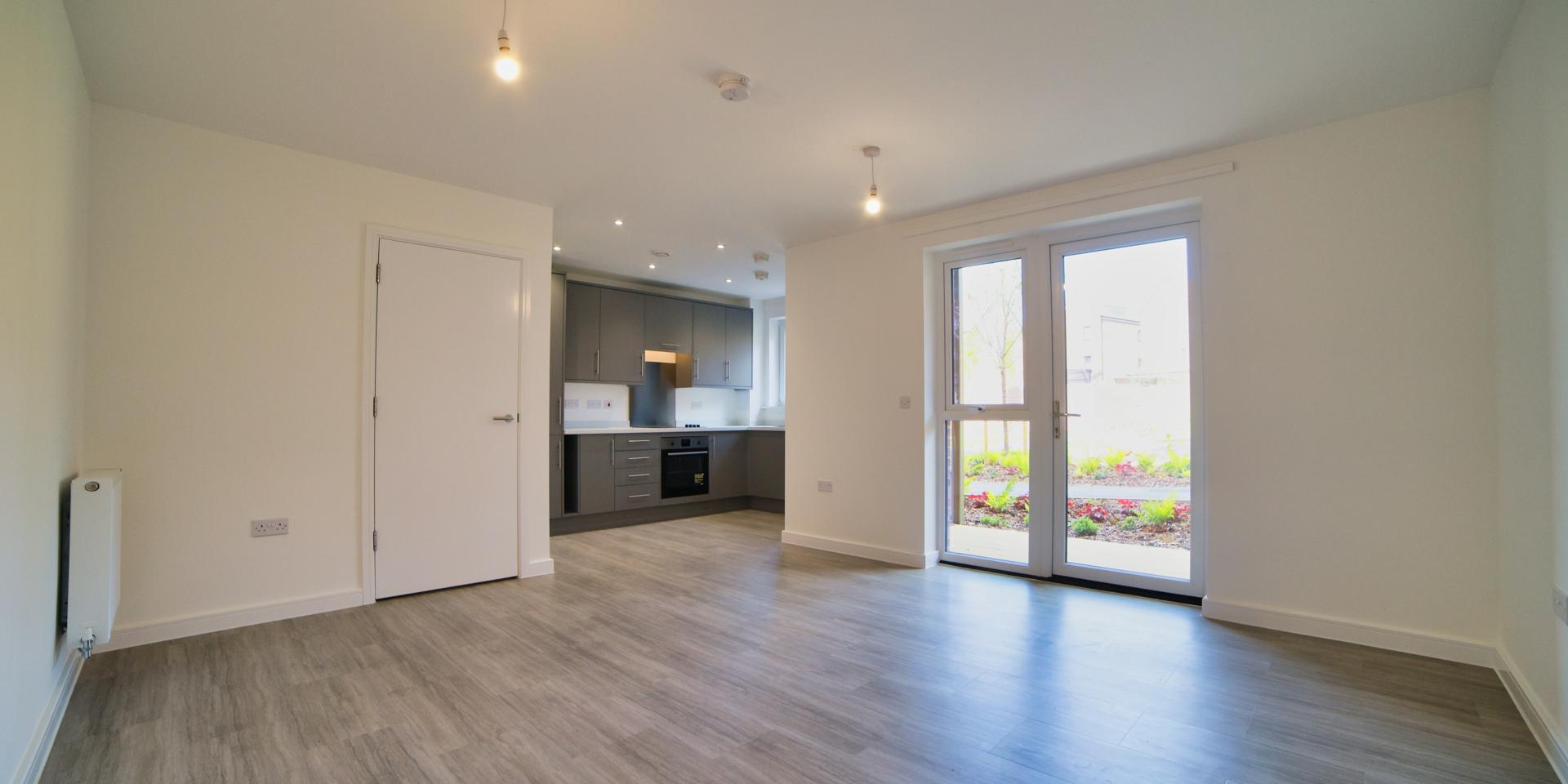 The living/dining room has a patio door leading you to the back of the building overlooking a play area and landscaped gardens