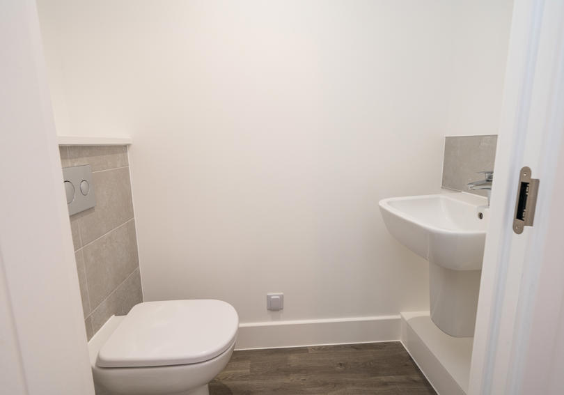 Downstairs cloakroom with white toilet and wash hand basin
