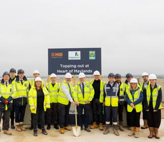 Hightown staff and stakeholders in hi-vis jackets and hard hats and the MP is holding a shovel