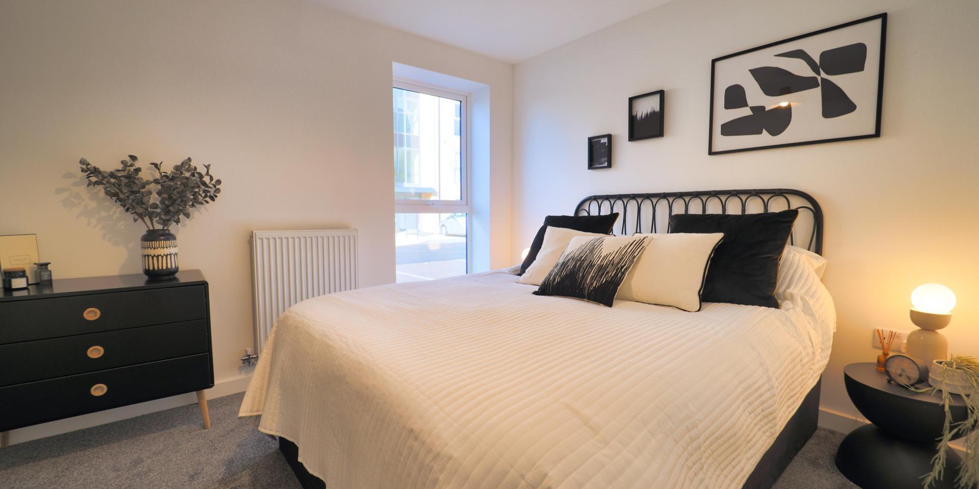 There is a double bed, bedside tables, freestanding clothes rail and chest of drawers