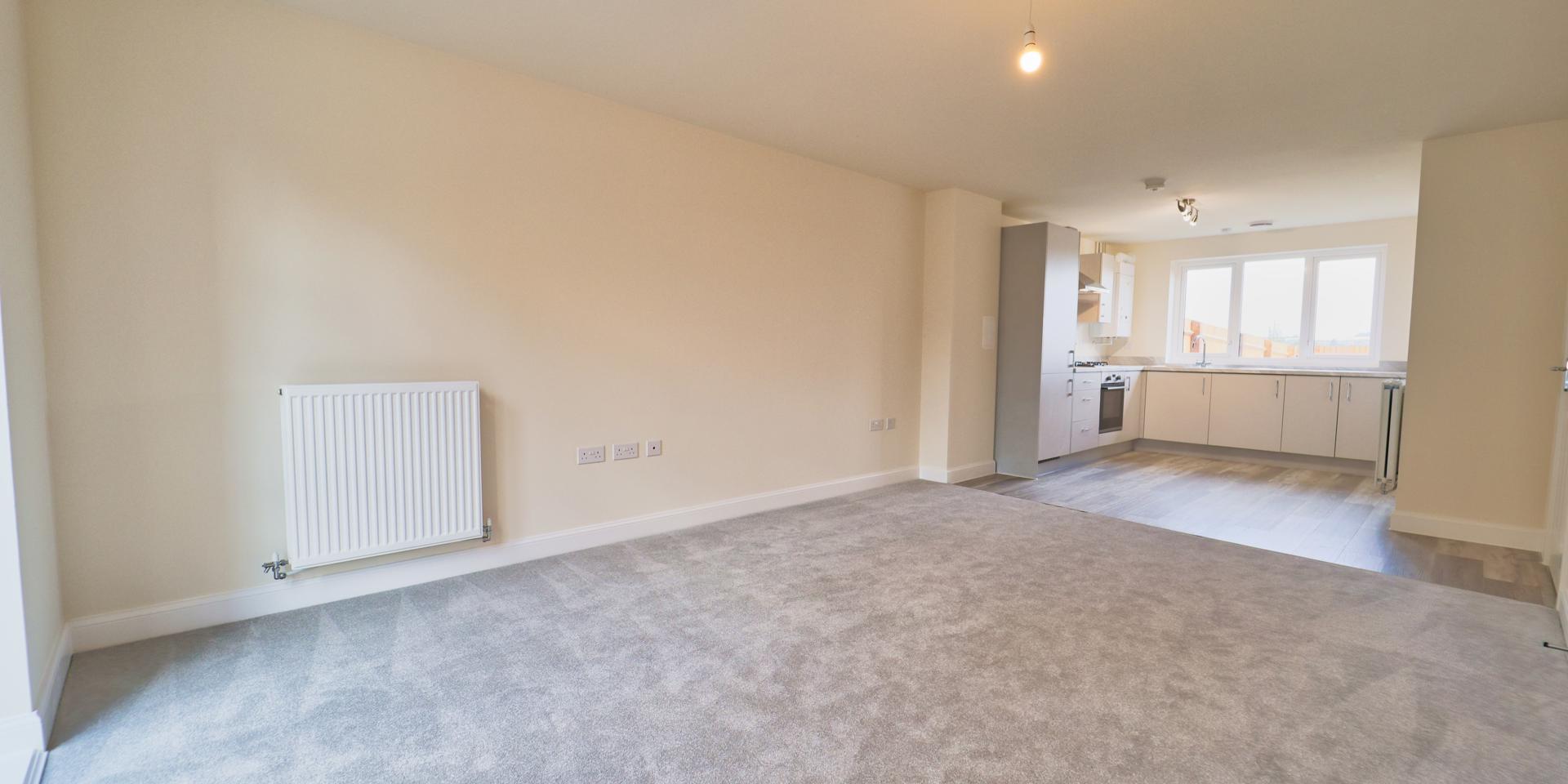 The kitchen is positioned at the rear of the house and has grey vinyl flooring