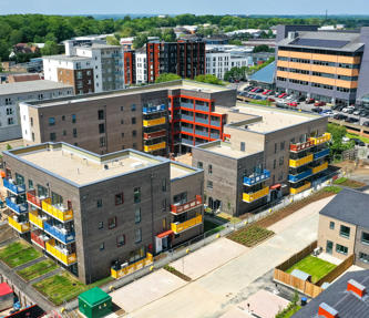 Flats and houses in construction. The flats have colourful balconies in blue, yellow and red. 