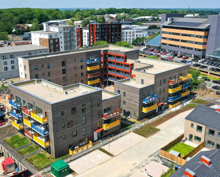 Flats and houses in construction. The flats have colourful balconies in blue, yellow and red. 