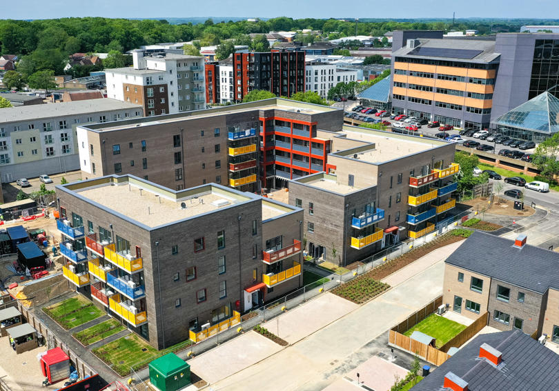 Flats and houses in construction. The flats have colourful balconies in blue, yellow and red.