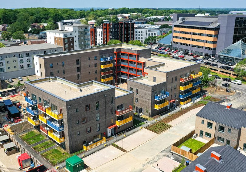 Flats and houses in construction. The flats have colourful balconies in blue, yellow and red. 