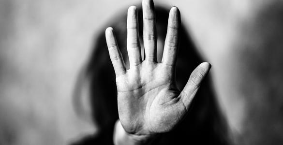 A woman with her hand in front of her face, signally to stop