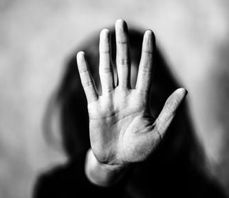 A woman with her hand in front of her face, signally to stop