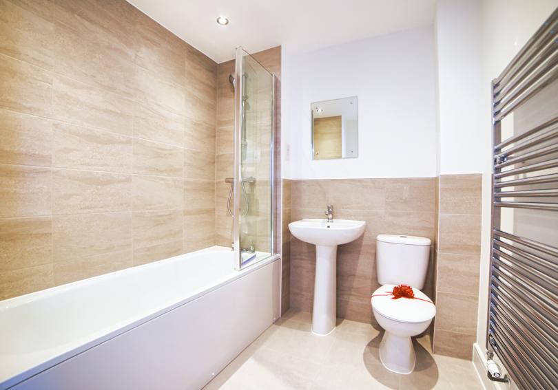 The bathroom with its white bathroom suite, bath and shower over the bath
