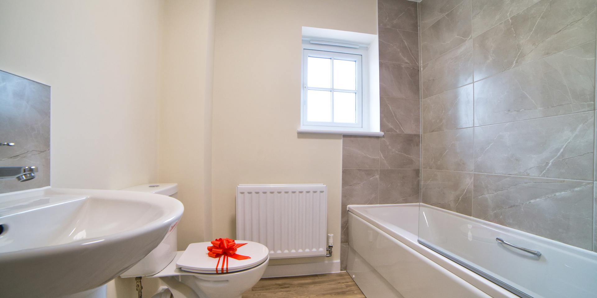 Fully fitted bathroom with white suite and shower over bath