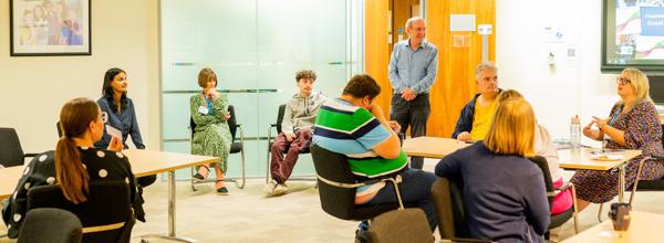 RVSP & VoiceBox joint event resident involvement event. People sat in a room talking. 