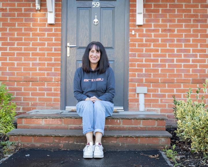 A mum sat on the steps outside of her new shared ownership property