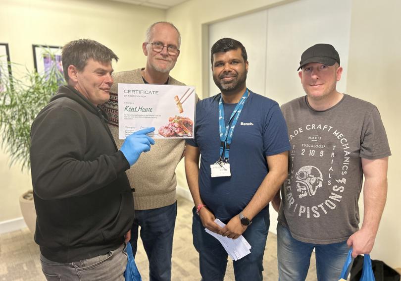 Three participants and Hetul, a Hightown staff member, hold a certificate of participation for the cook off