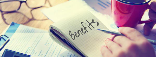 A person calculating costs and making notes about claiming benefits