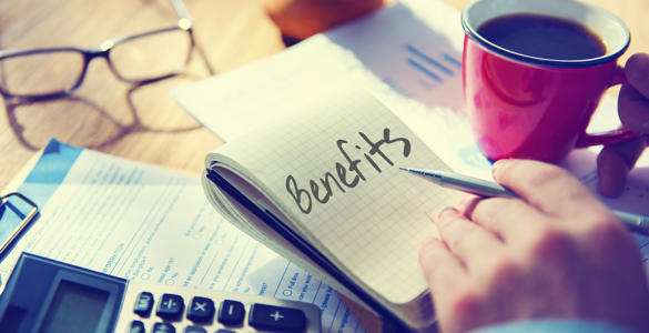 A person calculating costs and making notes about claiming benefits