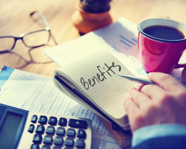 A person calculating costs and making notes about claiming benefits