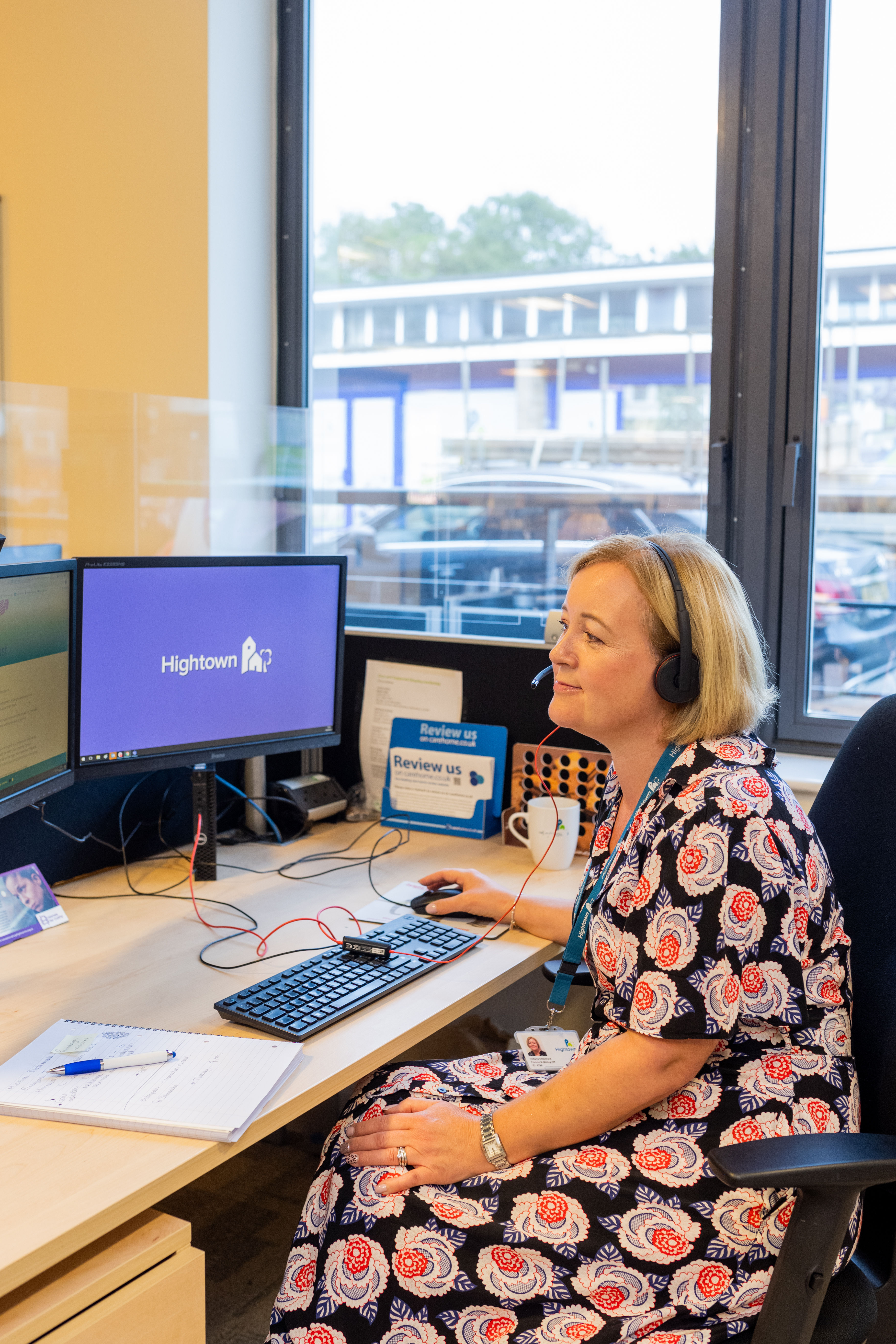 Staff member sat at her desk and making a phone call to a resident