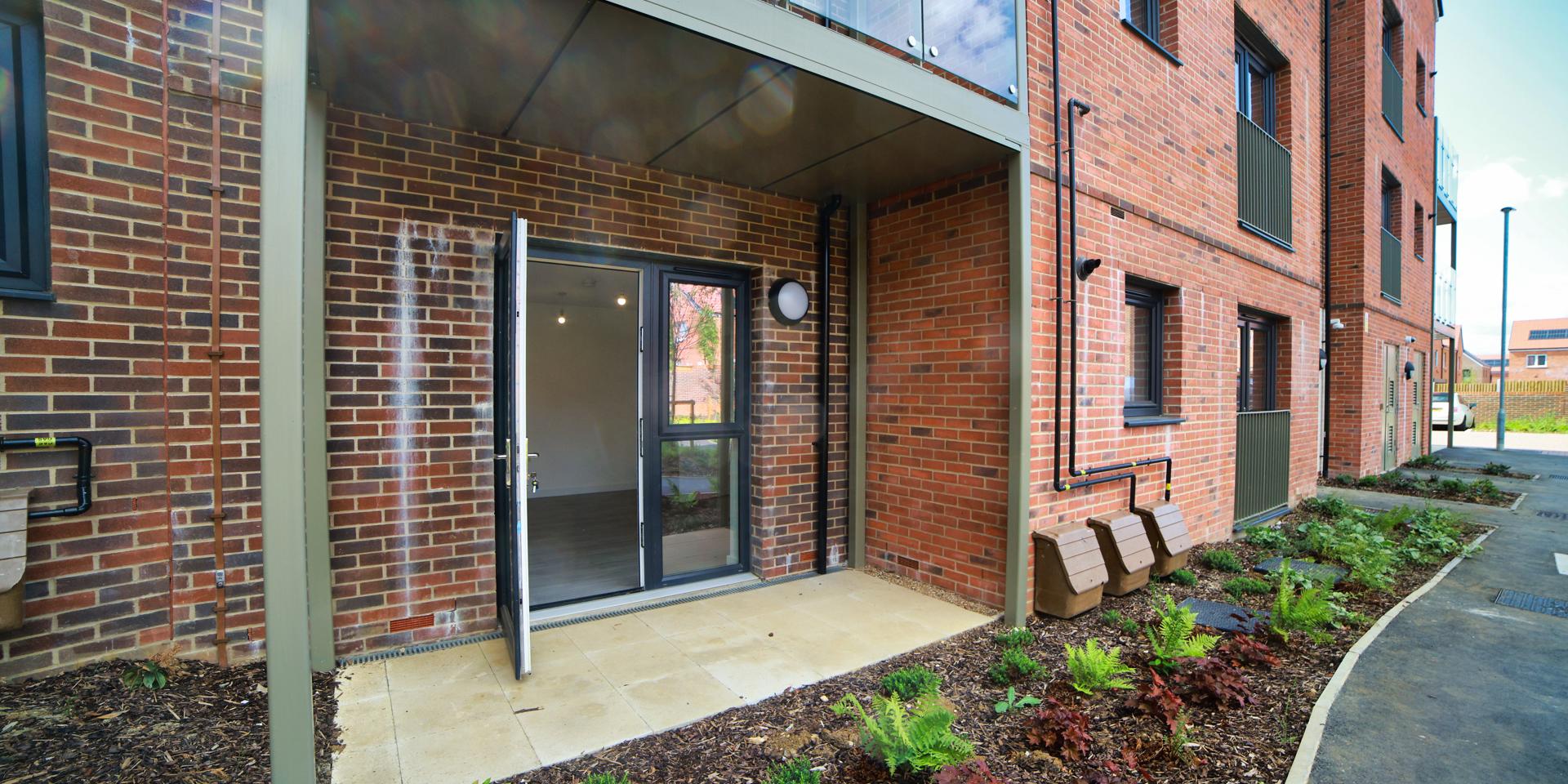 Around the patio is landscaped gardens and a pathway leading around the play area and to the car park at the front of the building