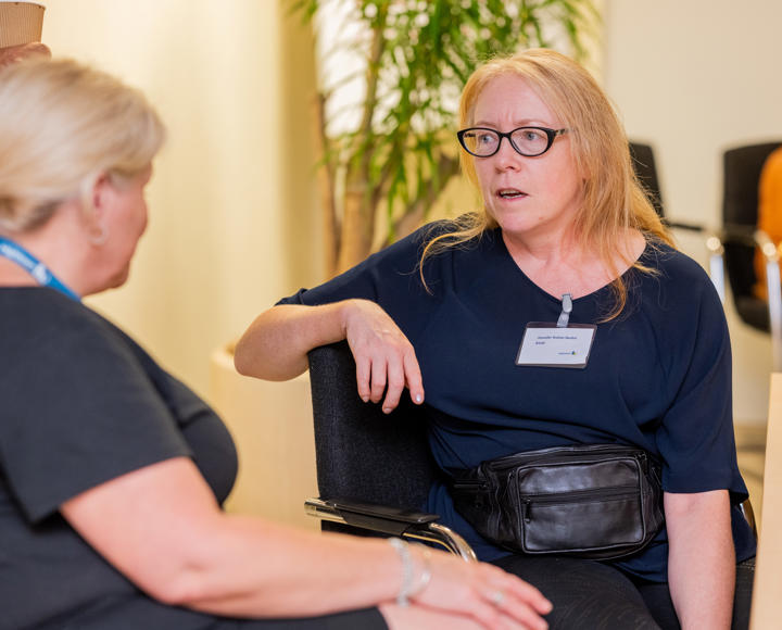 residents voice and scrutiny panel member talking to a member of staff.