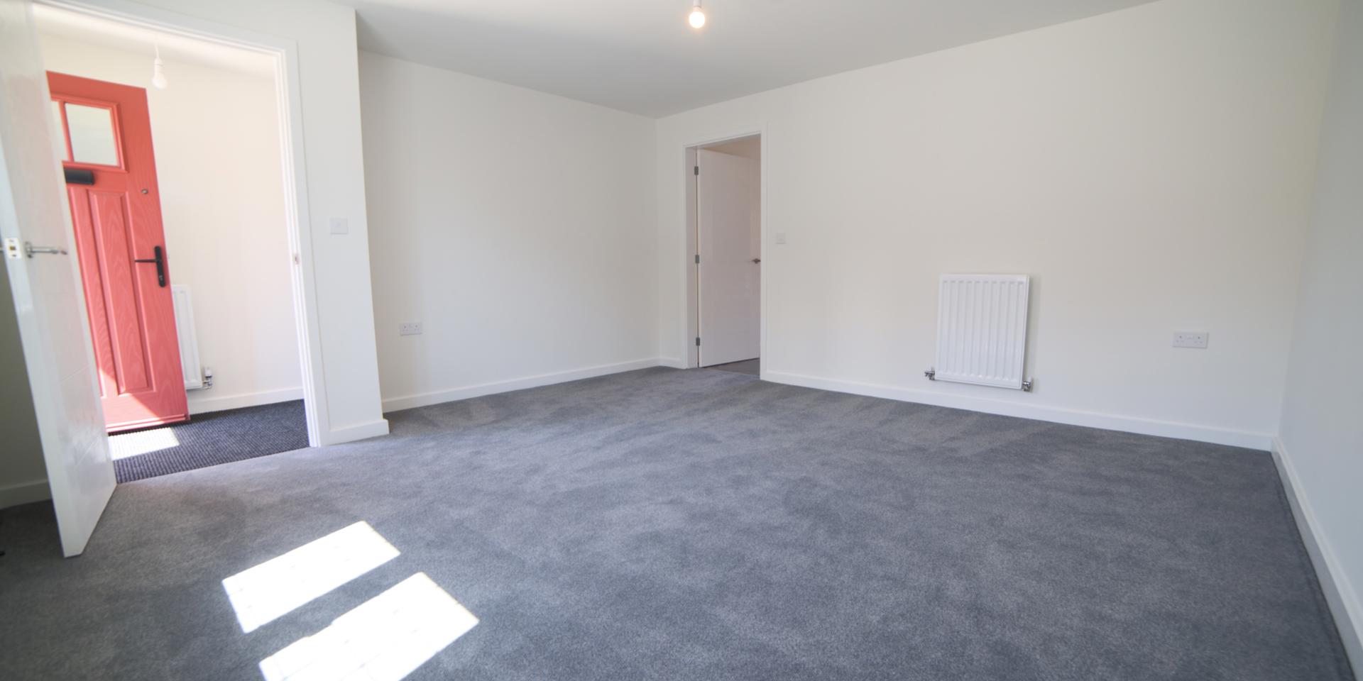 There is a spacious living room to the front of the property with grey carpet