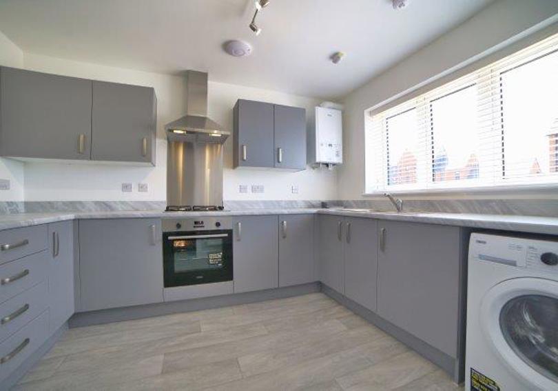 Image of the fitted kitchen including the integrated oven and hob and freestanding washer dryer