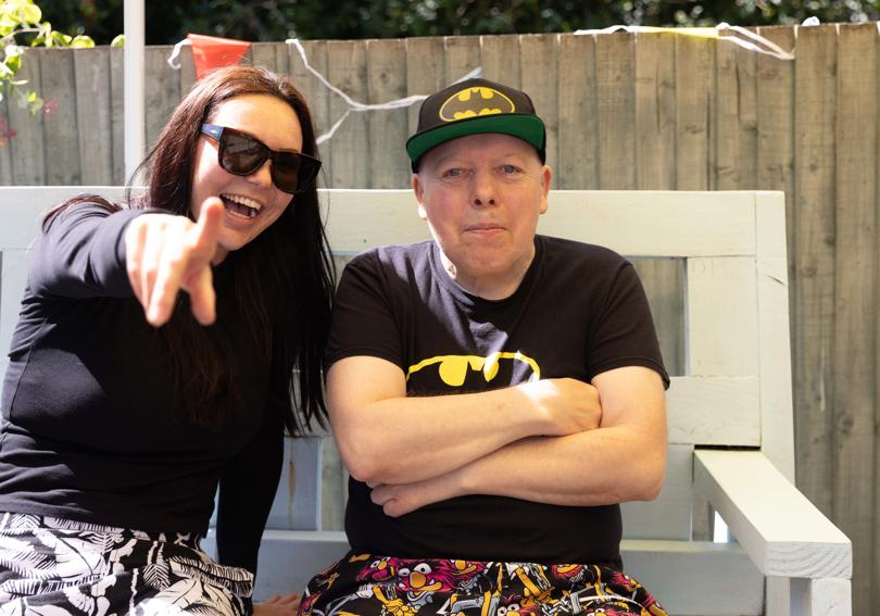 A service member and a Hightown staff member smile at the camera, as the staff member points at the camera. 