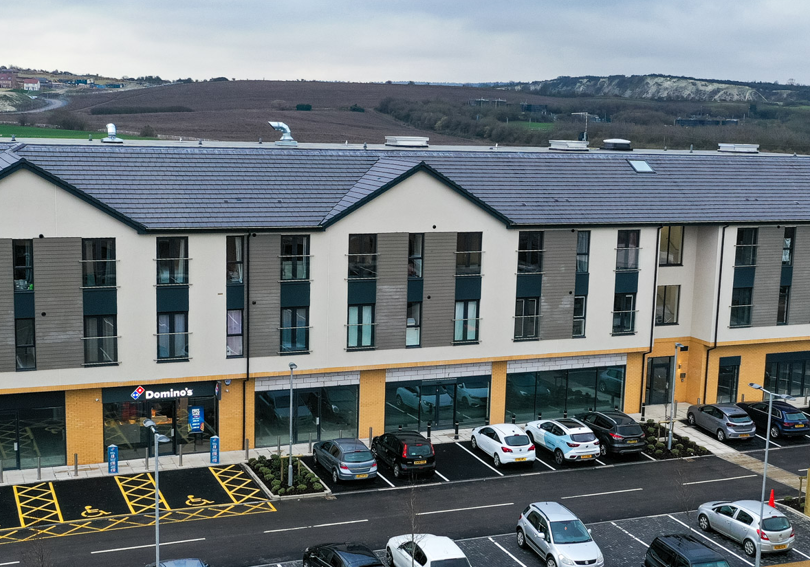 Aerial view of new flats and shops. The shops are below the flats.