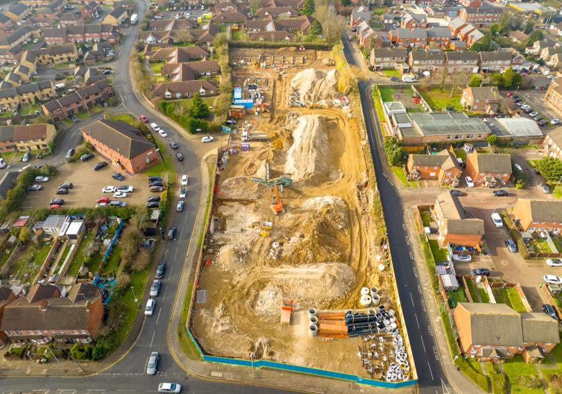 An aerial photo of a new housing development. The ground is dug up and there are building materials around.