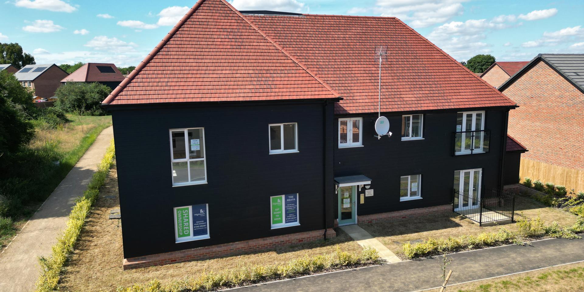An elevated view of the front of the apartment block. It's only one storey high.