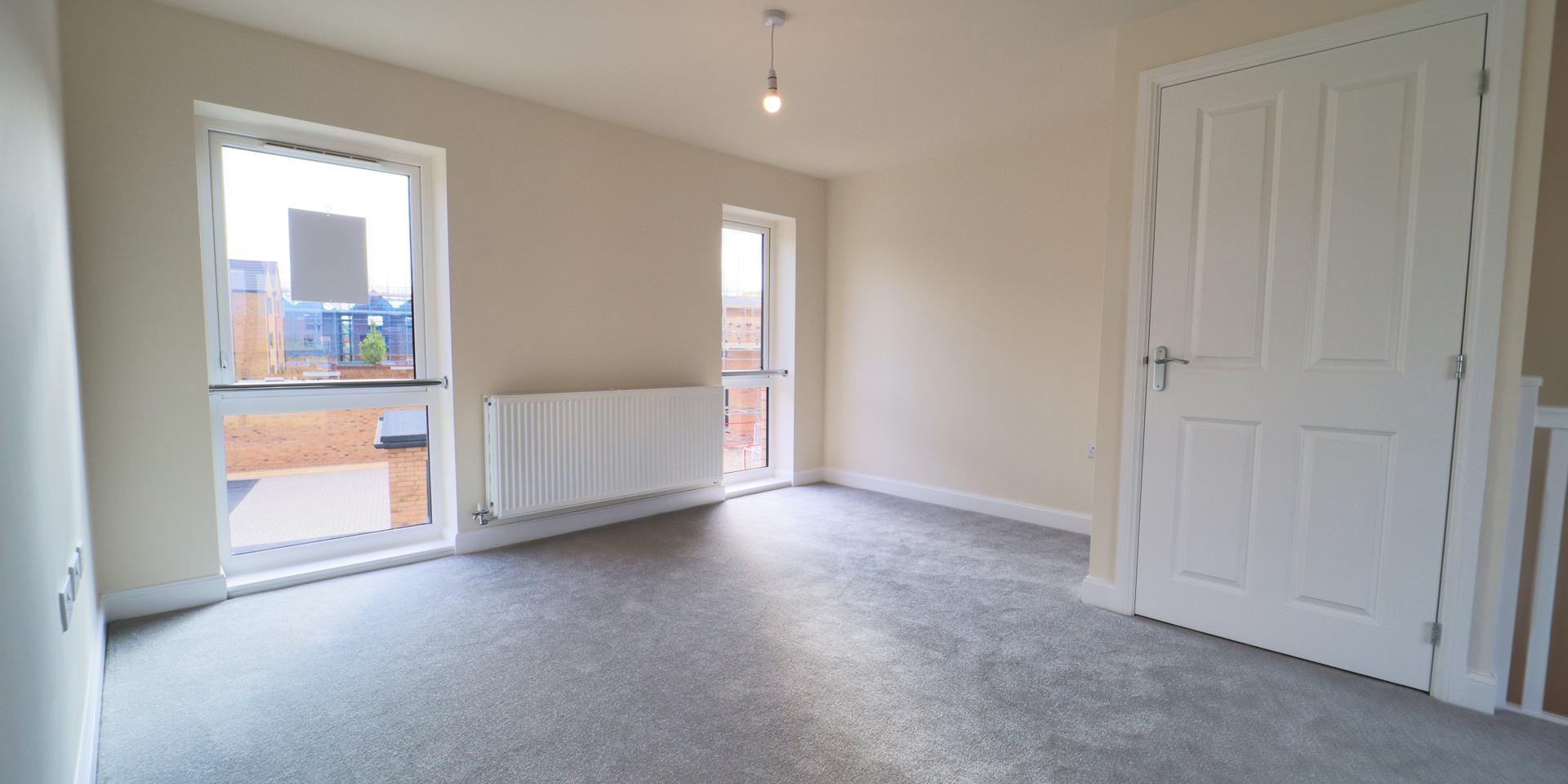 There are 3 large windows in the living area over looking the front and rear of the property. The carpet is a light grey colour.