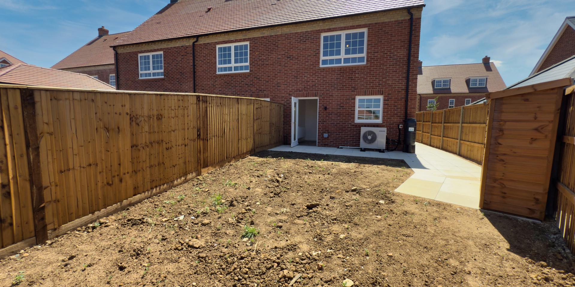 A view across the garden looking at the back of the house. The garden will be turfed.