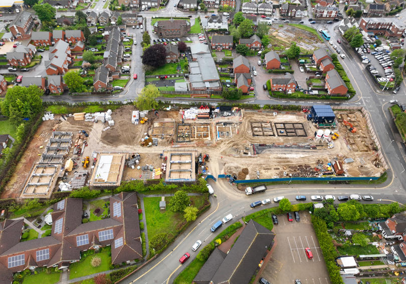 An aerial photo of a new housing development site and the surrounding area, comprising of green spaces and houses.