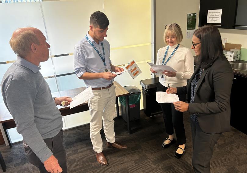 Hightown staff looking at the score cards of the cook off