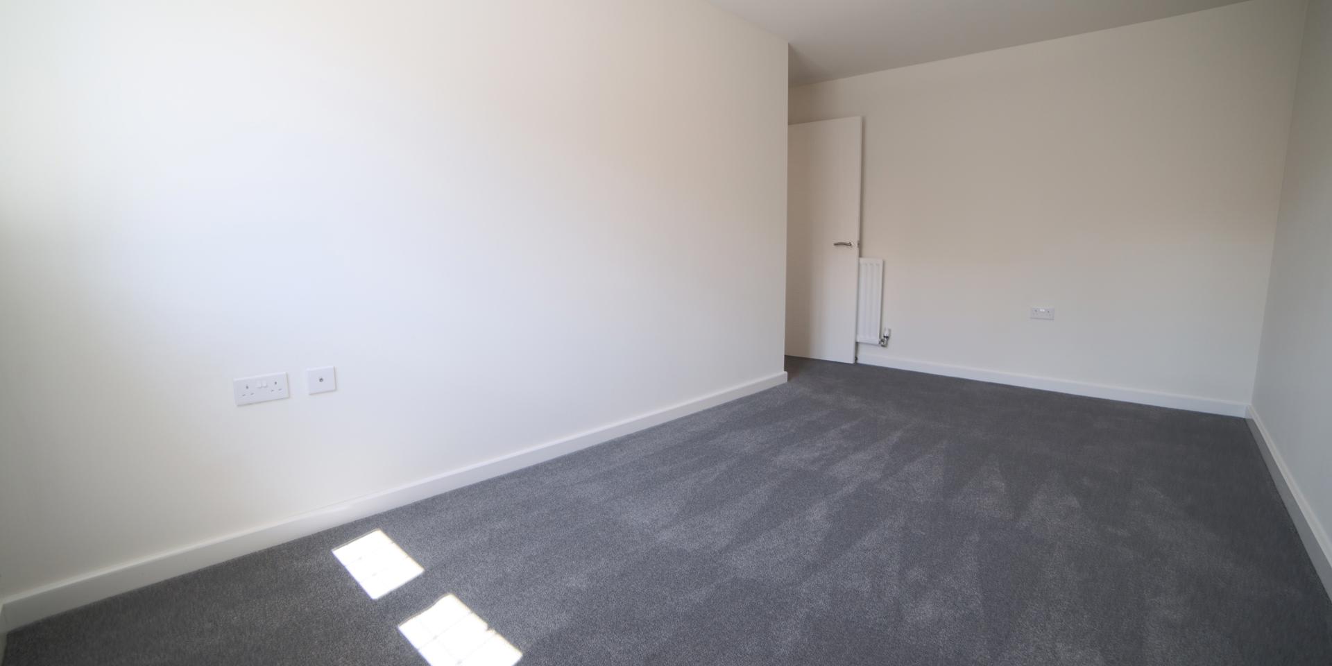 Bedroom 2 is a large double room with grey fitted carpet