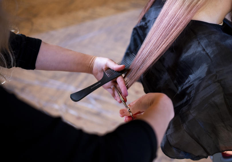 A hairdresser cutting a service user's hair at a Hightown homeless event in St Albans