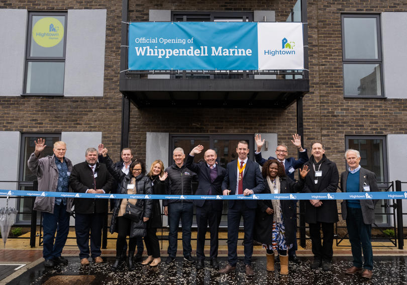 A group of official people, including the CEO of Hightown opening a new development of flats.