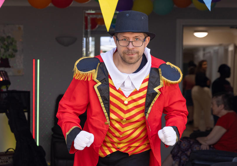 A service user dresses up in a ring master's circus costume