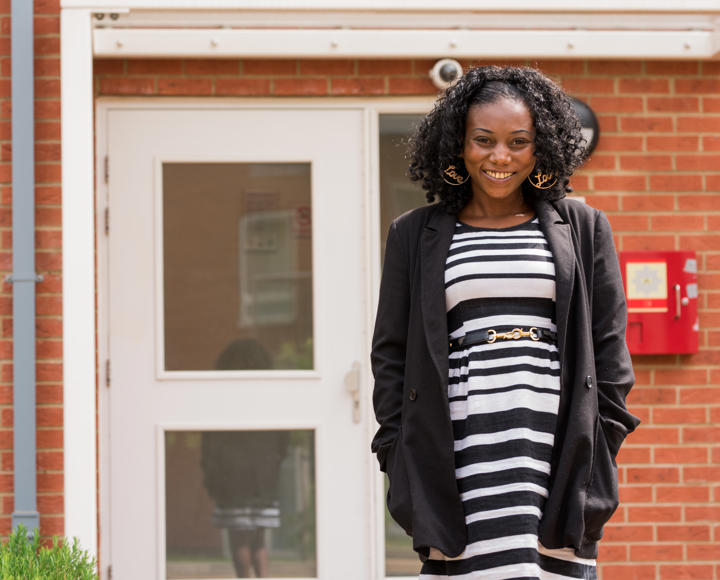 A young woman outside her new affordable rent property after facing homelessness