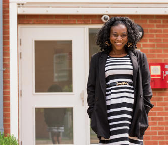 A young woman outside her new affordable rent property after facing homelessness