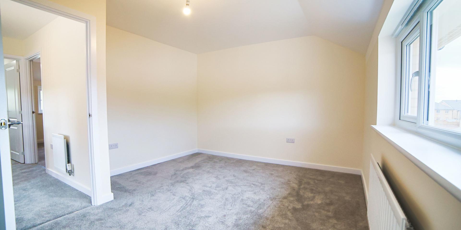 A different view of the main bedroom with its slightly sloped celings