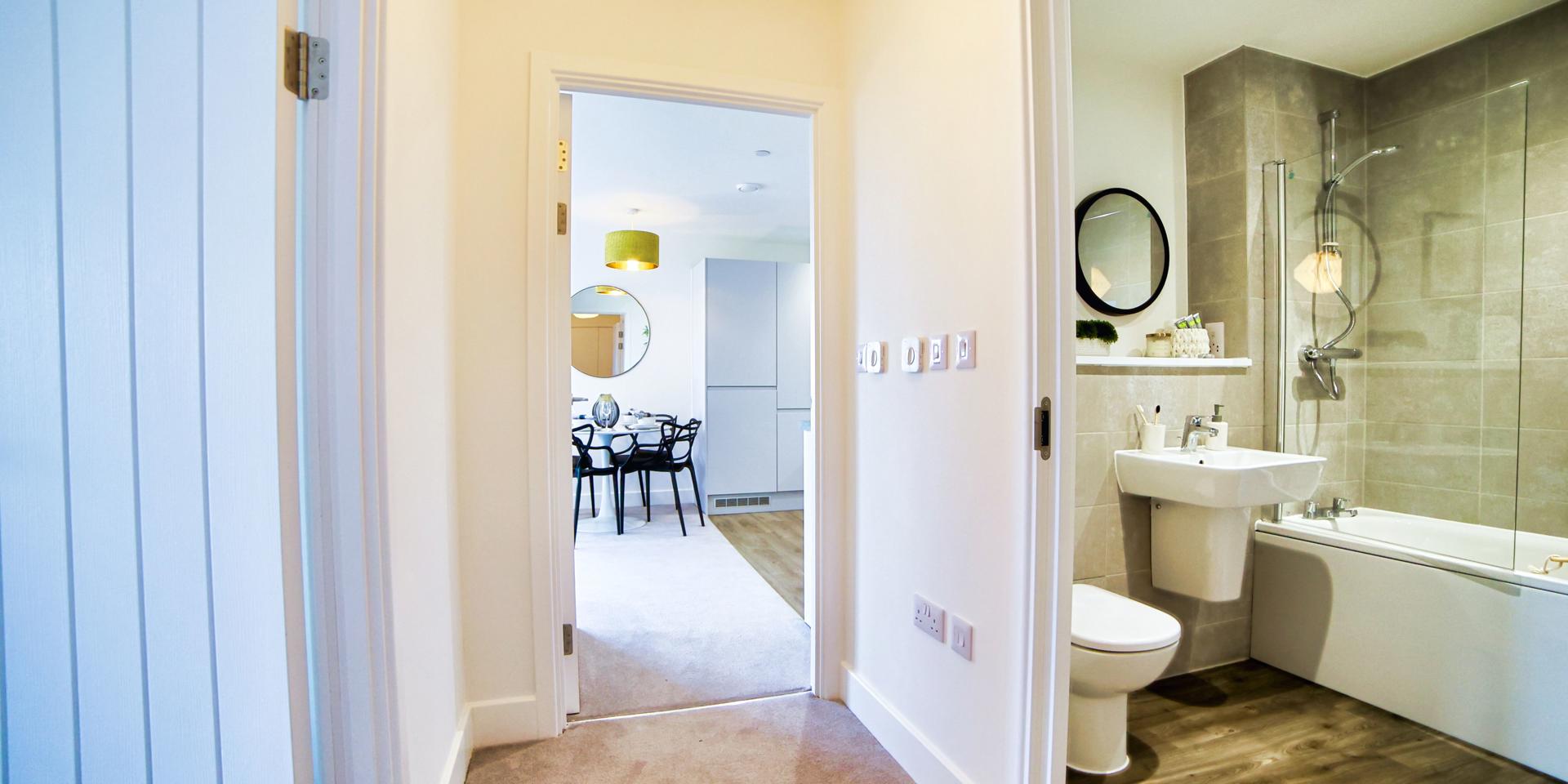 A view of the hallway showing the doorway to the bathroom and kitchen