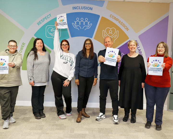 Four members of Hightown's Customer Experience Panel and Two Hightown staff holding up signs that read: Customer Experience Panel