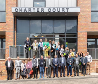 A group of people, including the CEO of Hightown standing outside of a new development of flats