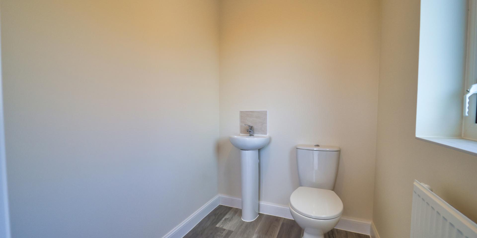 White WC and sink with a small window to allow natural light in