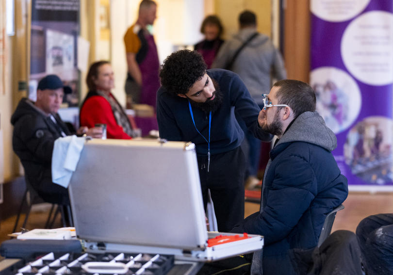 An optician giving an eye test to a service users, St Albans Hightown Homeless Event