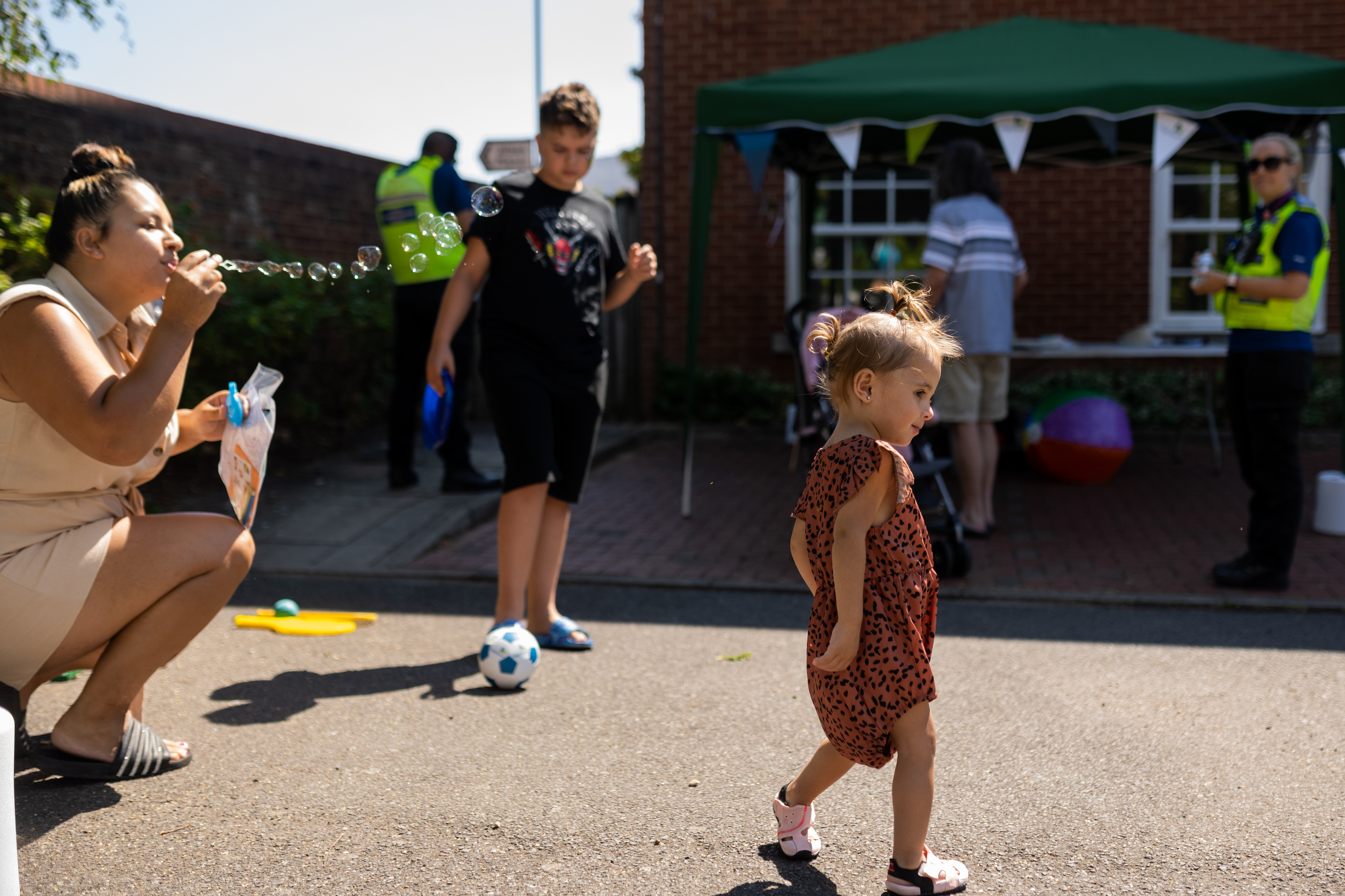 Mother blowing bubbles to her daughter at a Hightown resident's involvement event