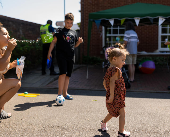 Mother blowing bubbles to her daughter at a Hightown resident's involvement event