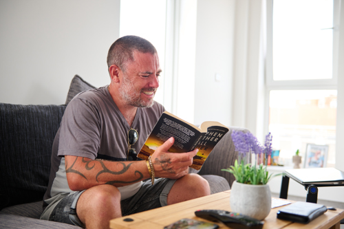 General needs resident sat in his new home reading a book