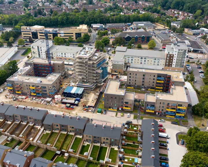 Aerial view of of a big new development, including flats and houses. 